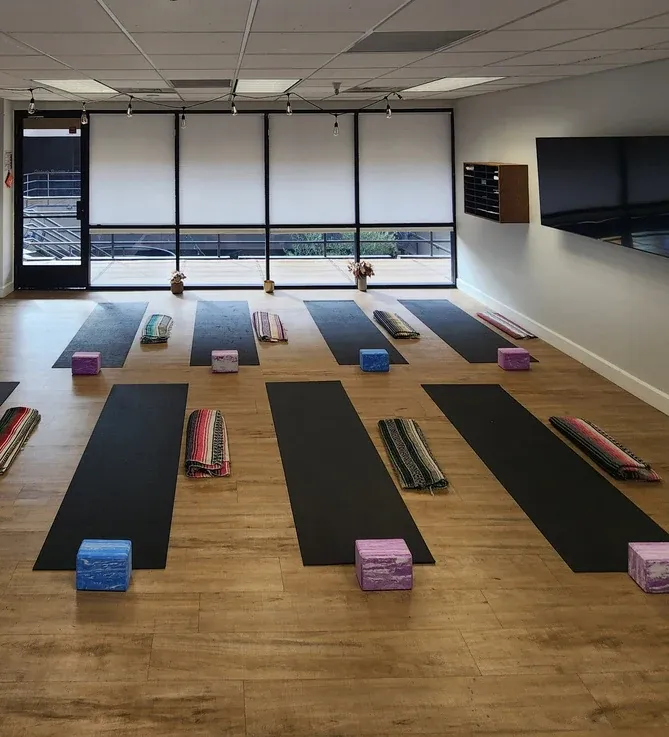 A welcoming group yoga space arranged with mats and supportive props