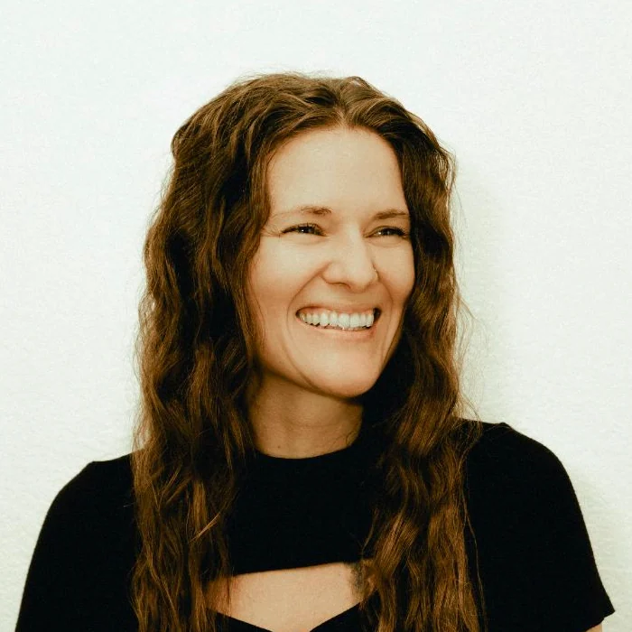 Tiffany Lehman smiling against a light studio wall
